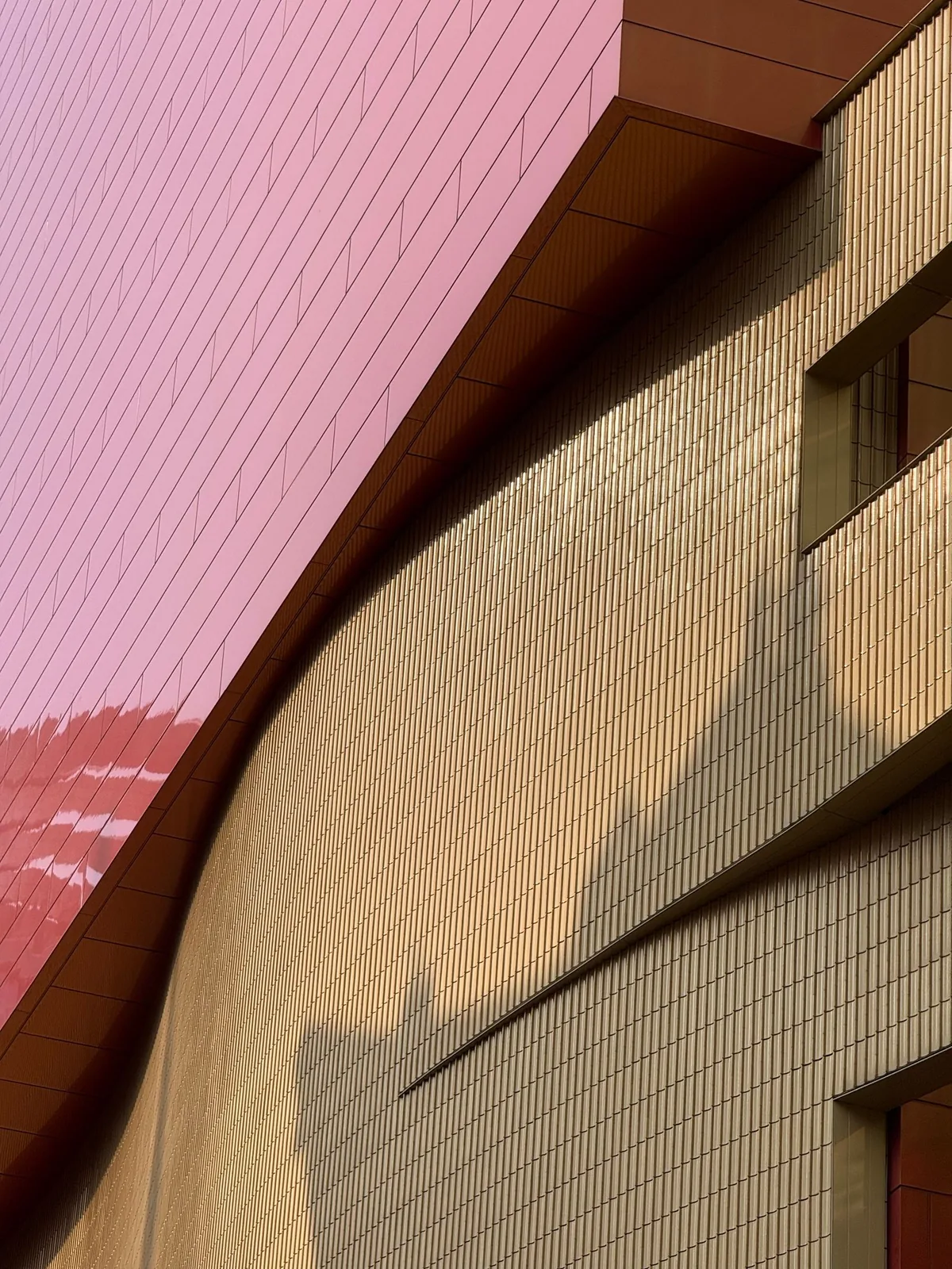 Geometric pink and cream architectural facade in sunlight